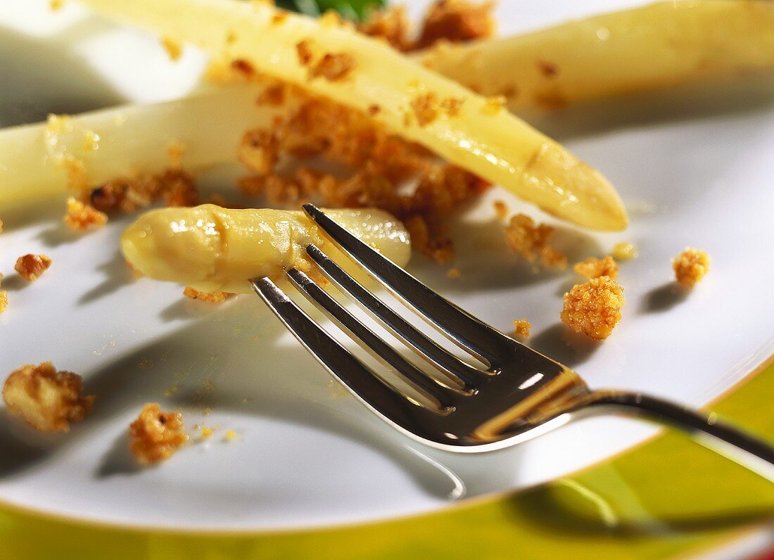 White asparagus with walnut crumbs on plate with fork