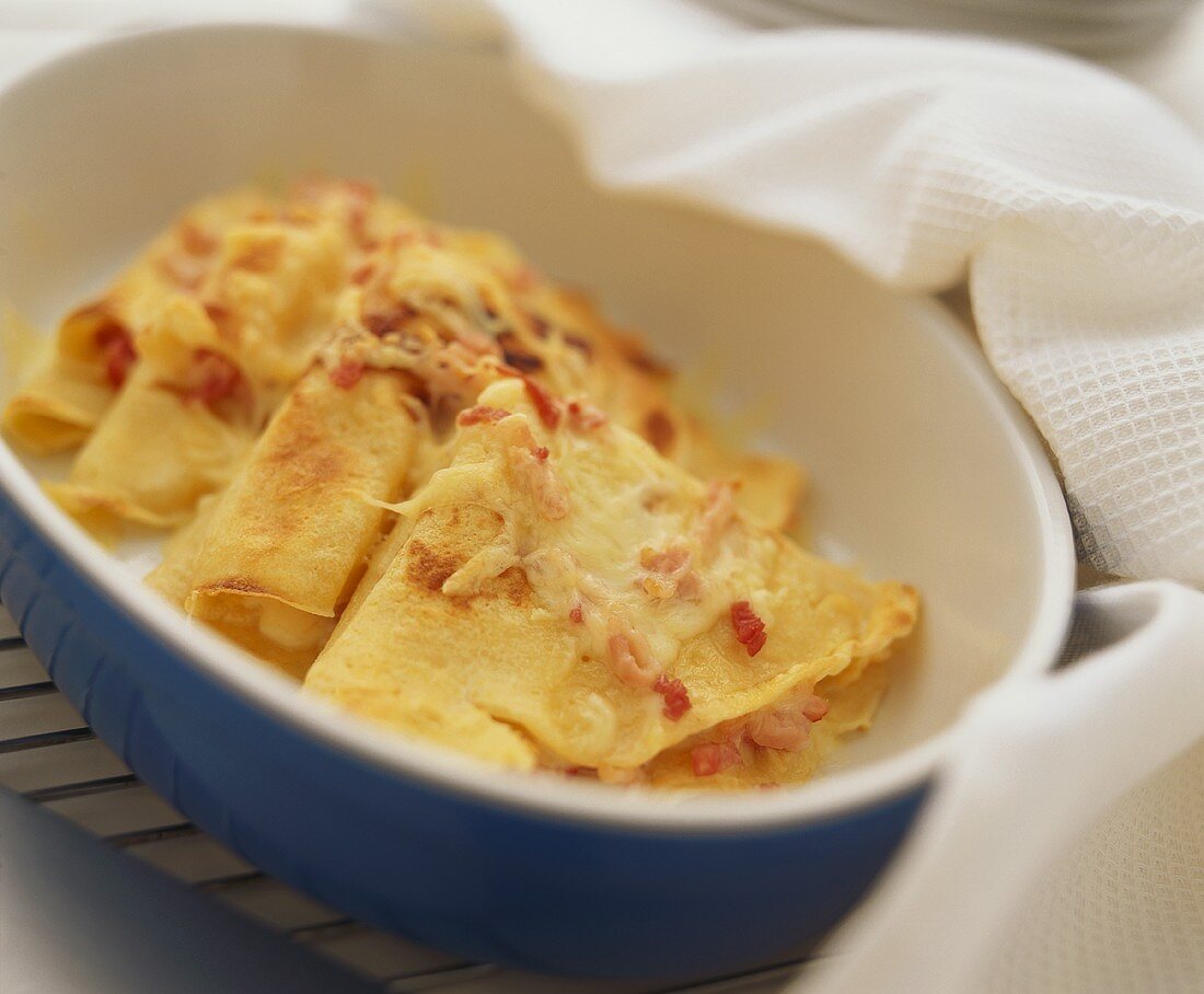 Hearty pancakes with bacon and cheese in baking dish