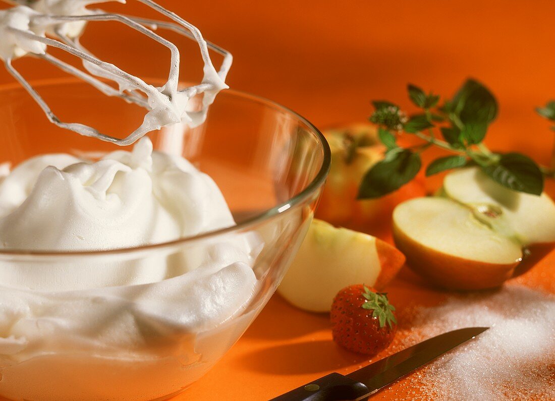 Schlagsahne in Glasschüssel, frisches Obst und Zucker