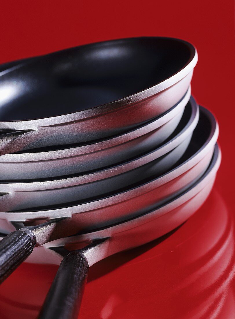 A pile of pans on red background