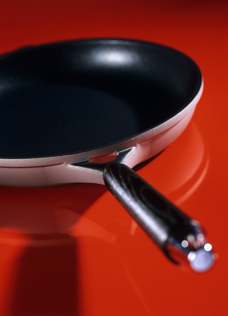 A frying pan on red background