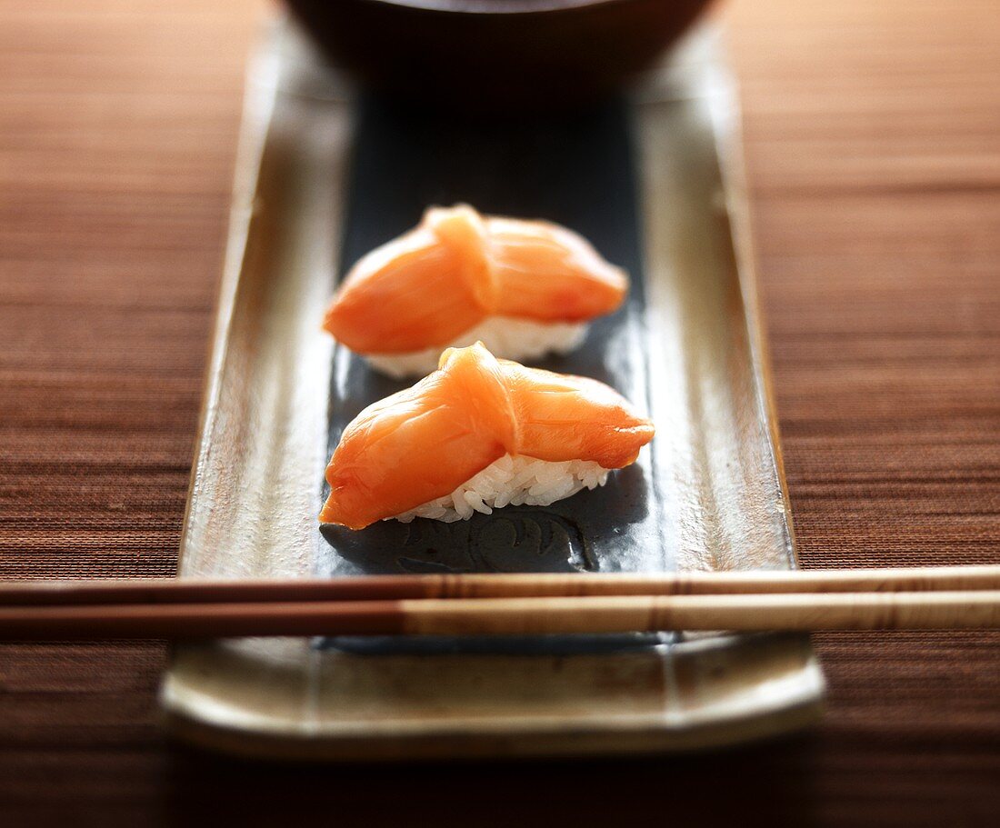 Nigiri Sushi mit roten Venusmuscheln auf Platte mit Stäbchen