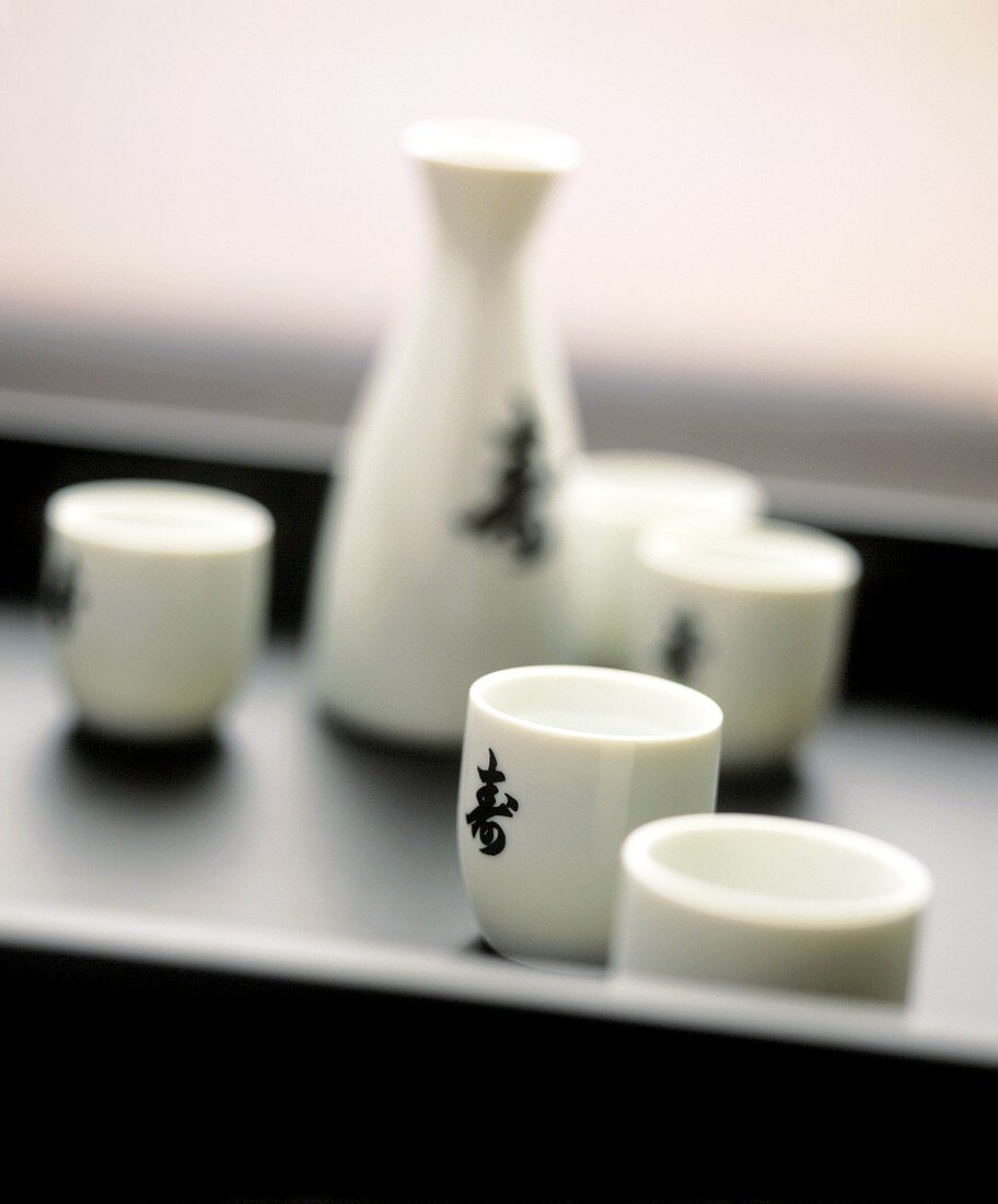 Japanischer Sake in Schälchen und Kännchen