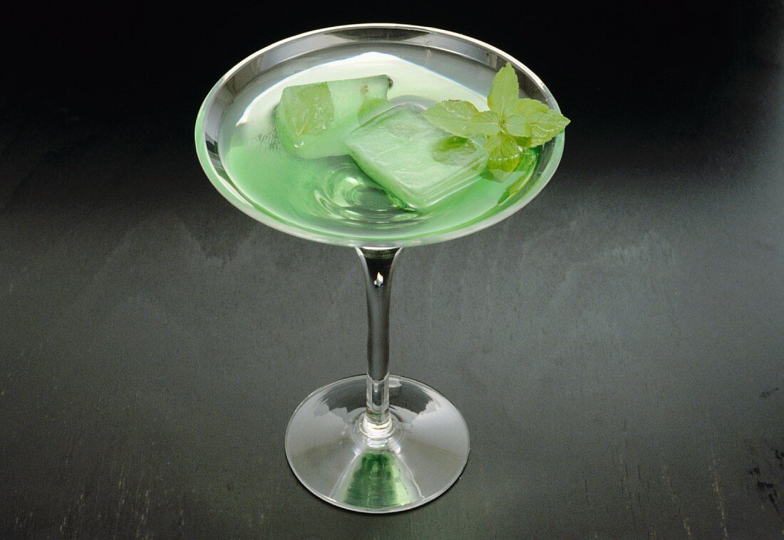 Minz-Cocktail mit Minzeiswürfeln in Sektschale