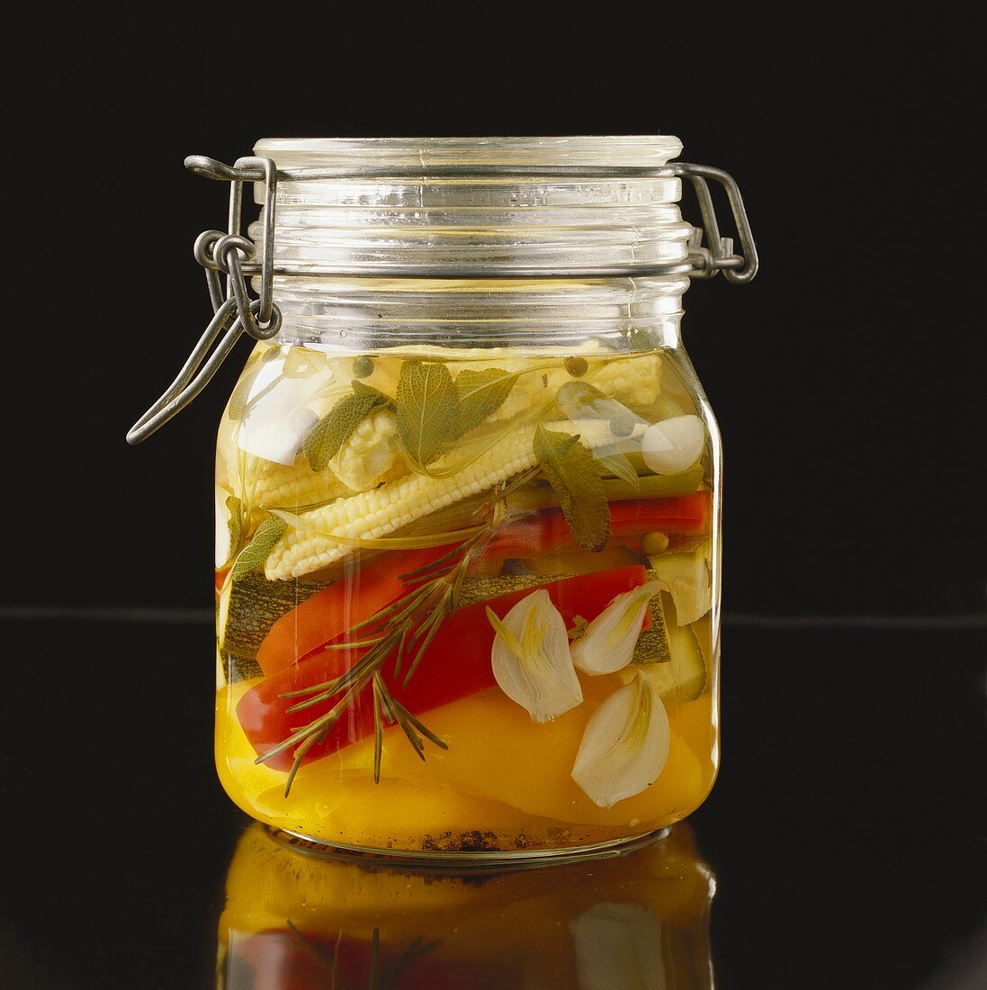 Bottled vegetables with herbs in preserving jar