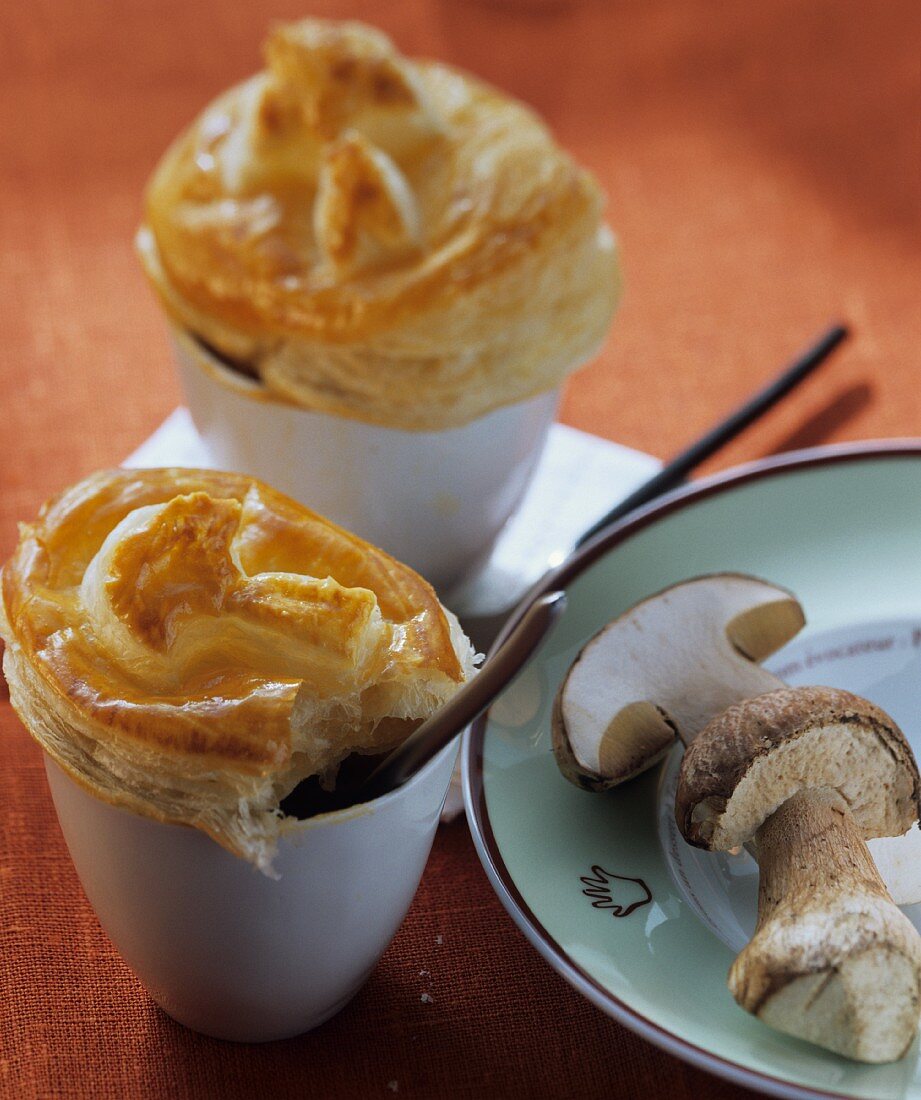 Cep consomme with puff pastry topping in white cups