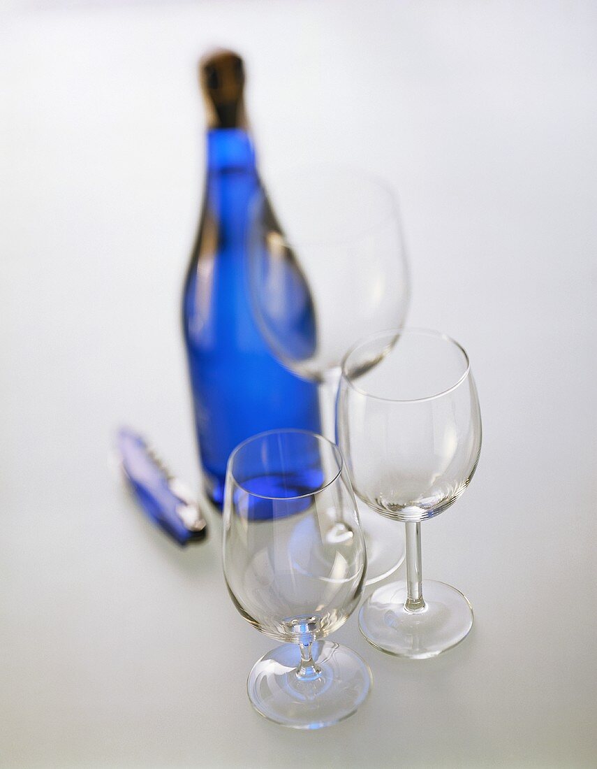 Empty wine glasses; sparkling wine bottle and waiter's knife