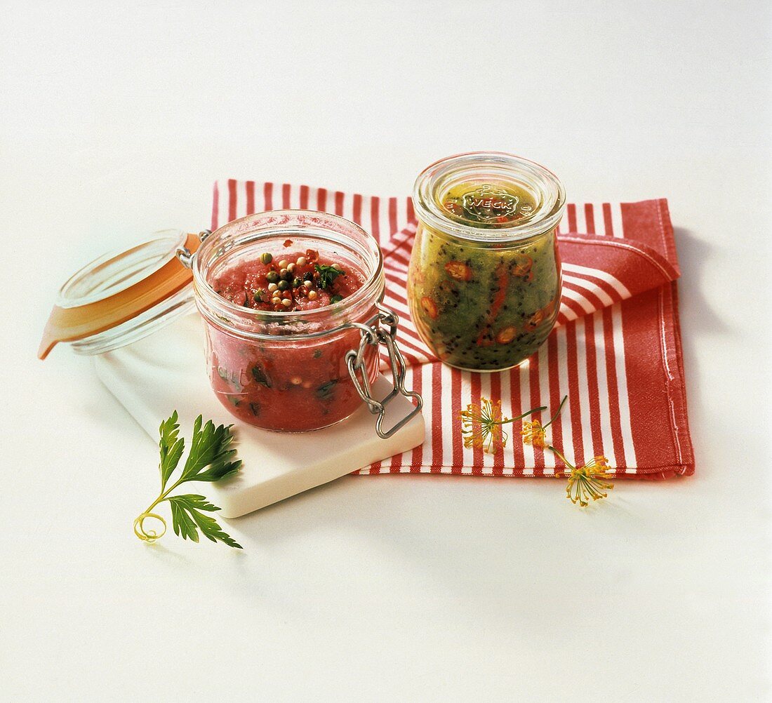 Two chutneys in pickling jars on striped cloth
