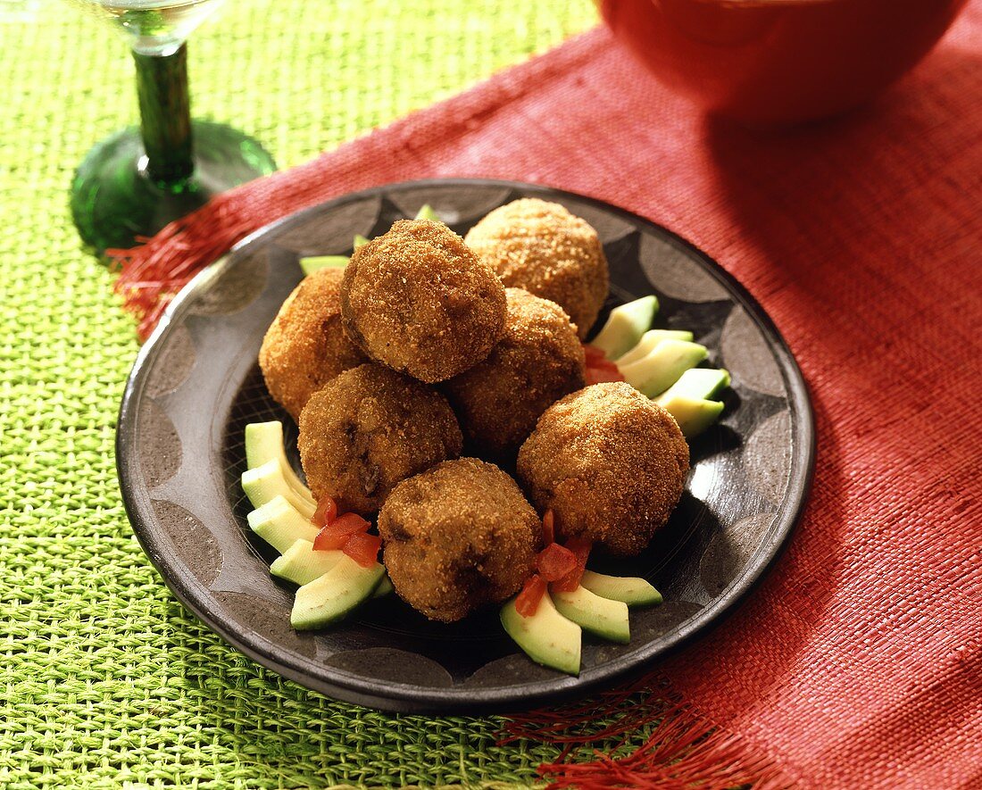 Fried meatballs with avocado and diced tomato