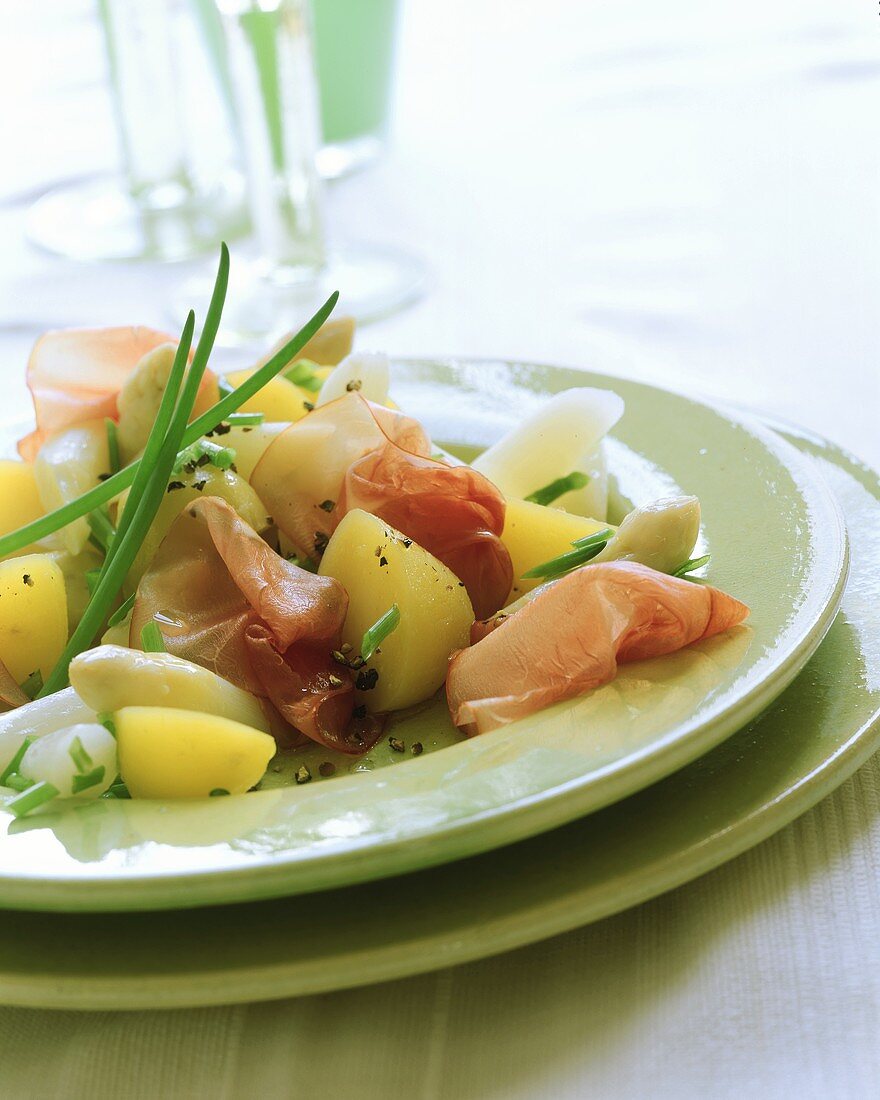 Potato and asparagus salad with raw ham and chives