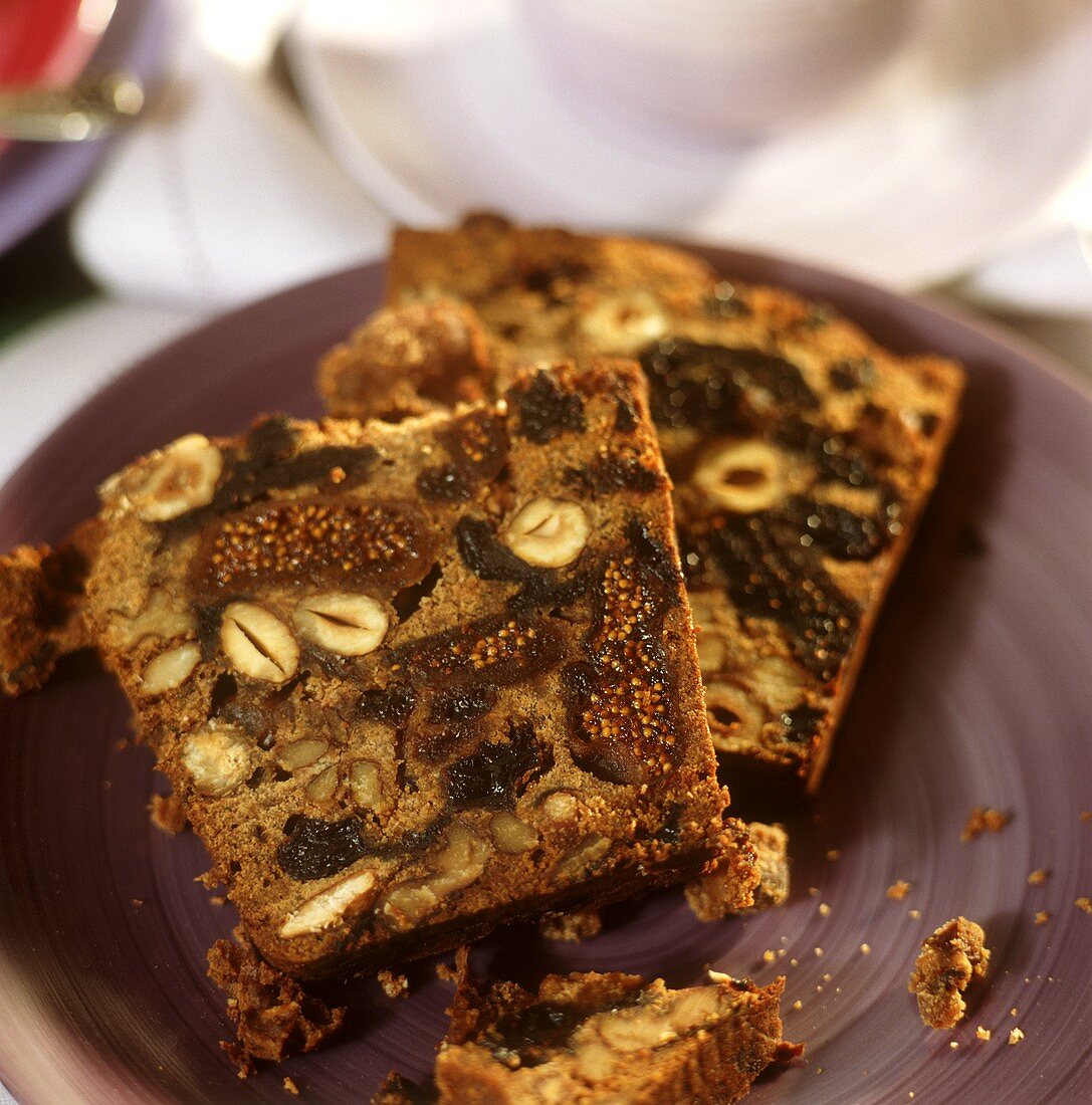 Zwei Scheiben Früchtekuchen mit Nüssen auf Teller