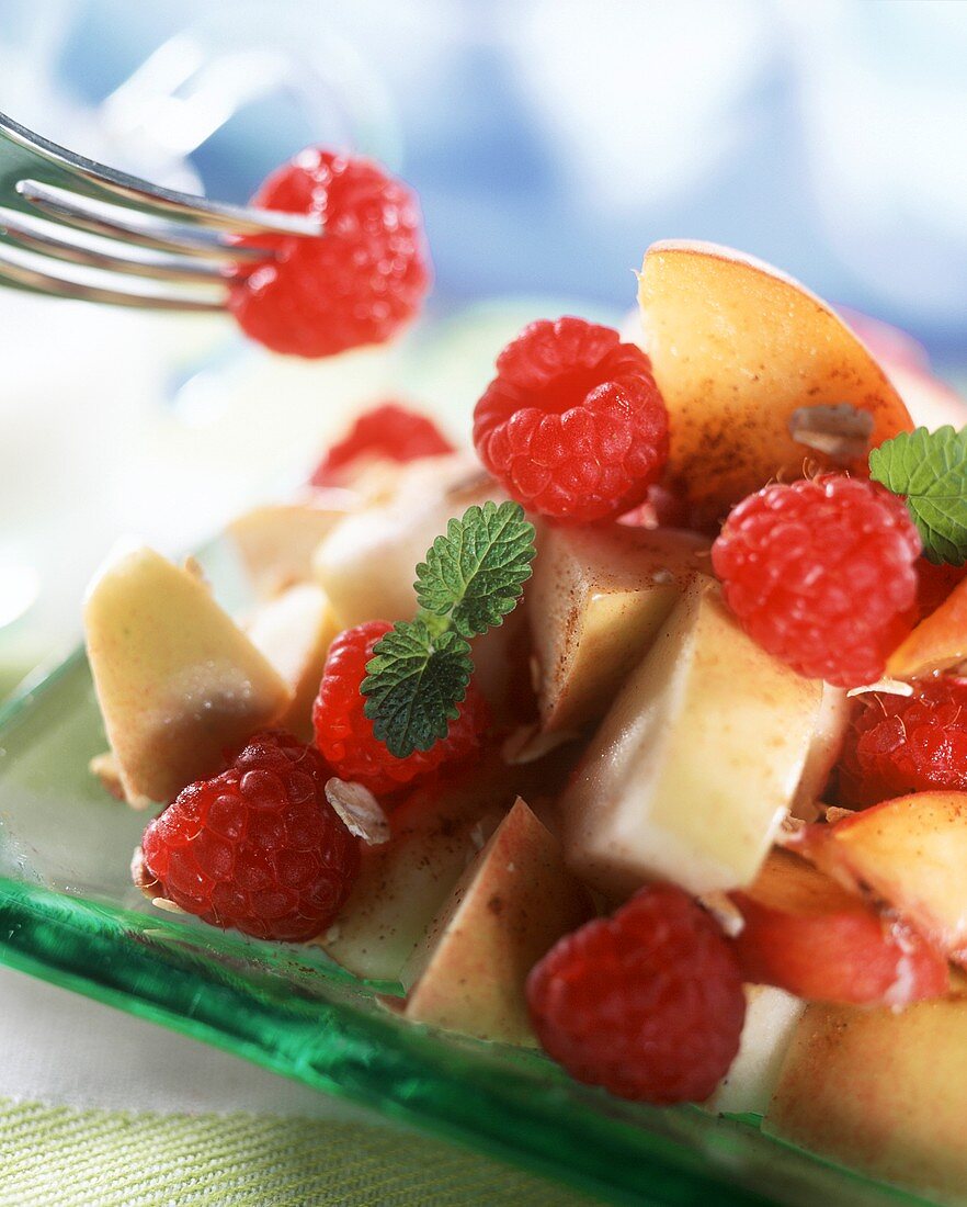 Obstsalat aus Äpfeln und Himbeeren mit Zimt