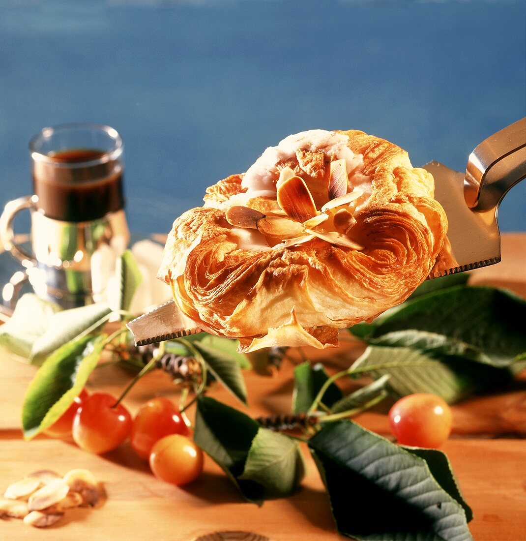 Almond pasty on cake slice; cherries; coffee