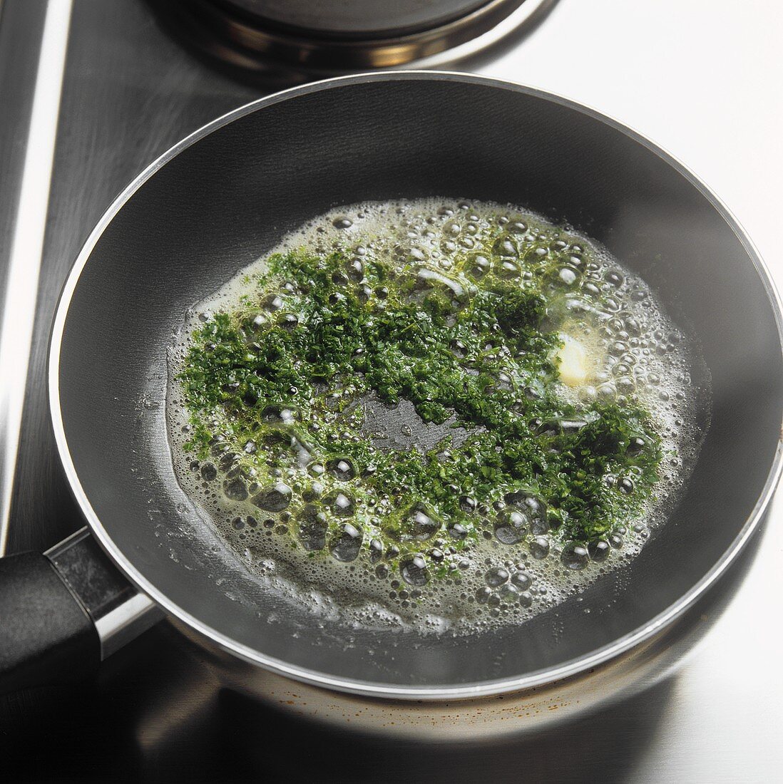 Sautéing chopped herbs in butter