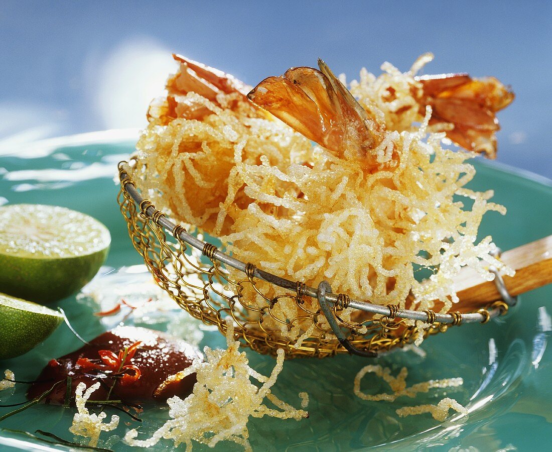 Deep-fried shrimps with glass noodles on slotted spoon