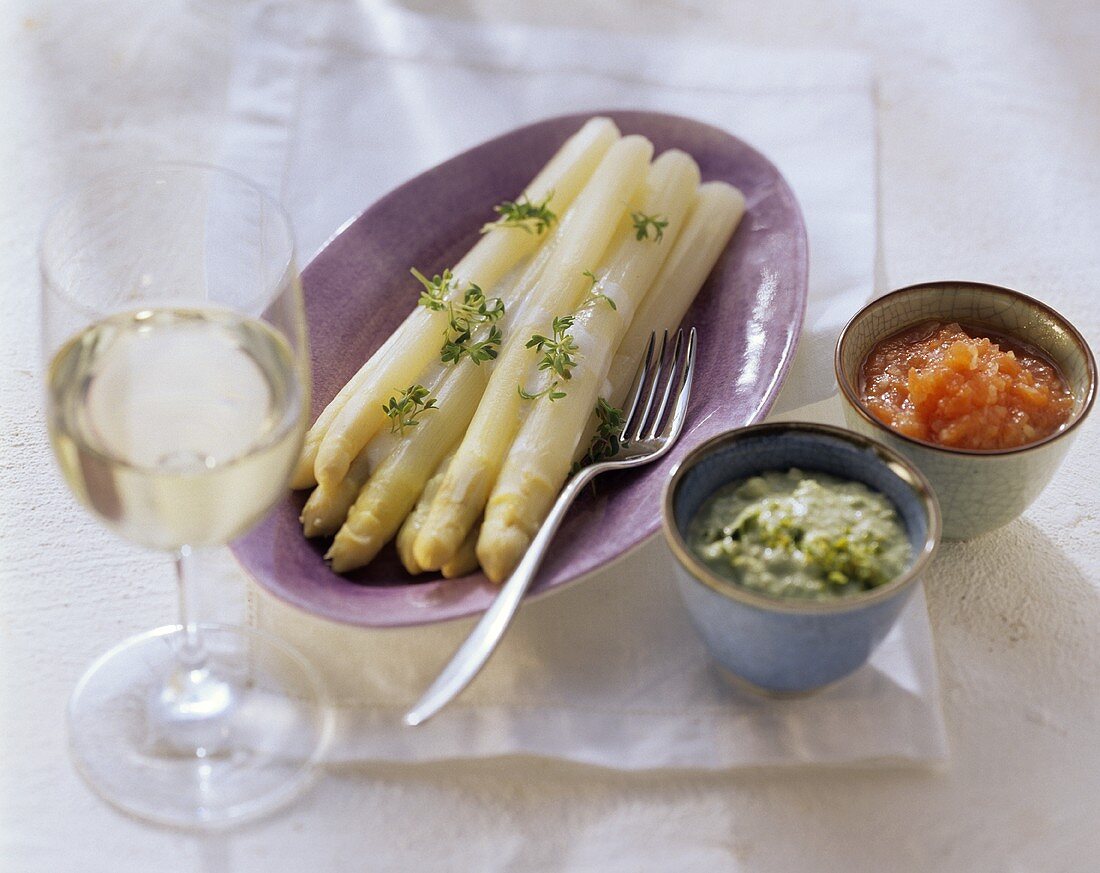 White asparagus with two sauces and white wine glass