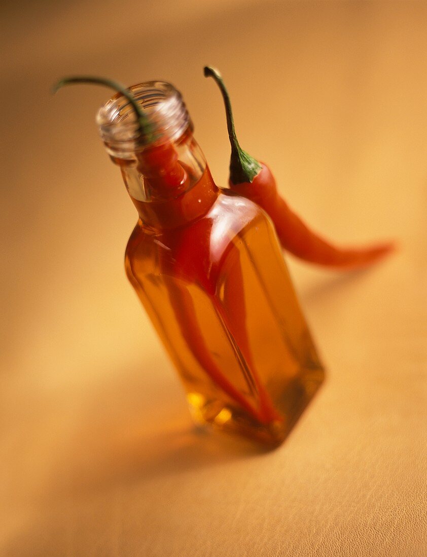 Chiliöl in Flasche und rote Chilischoten