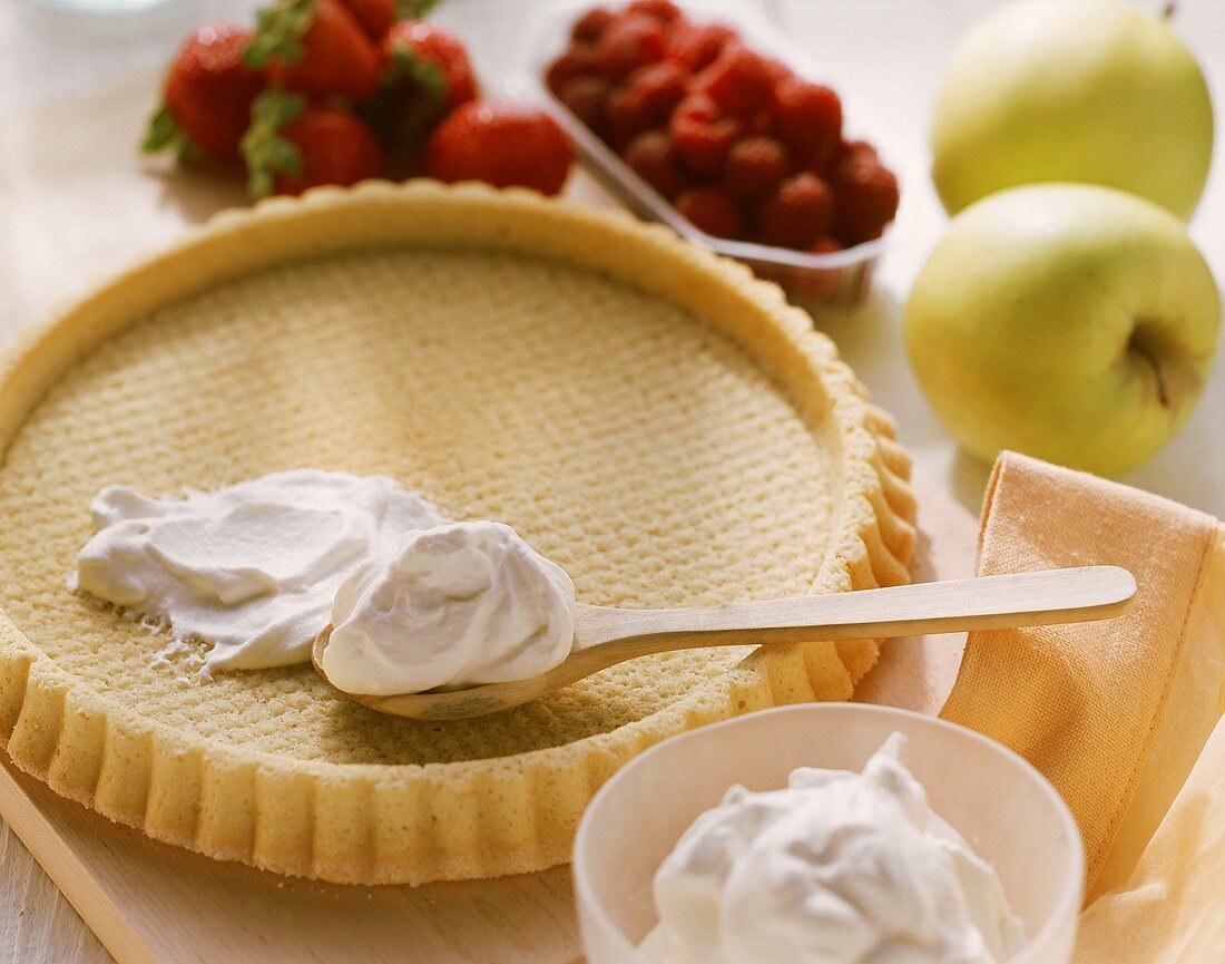 Tortenboden mit Sahne; frische Beeren und Äpfel