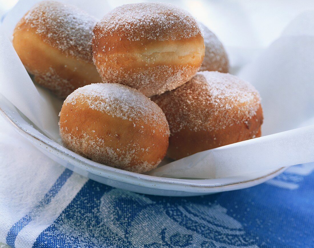 Fresh doughnuts with sugar on white plate