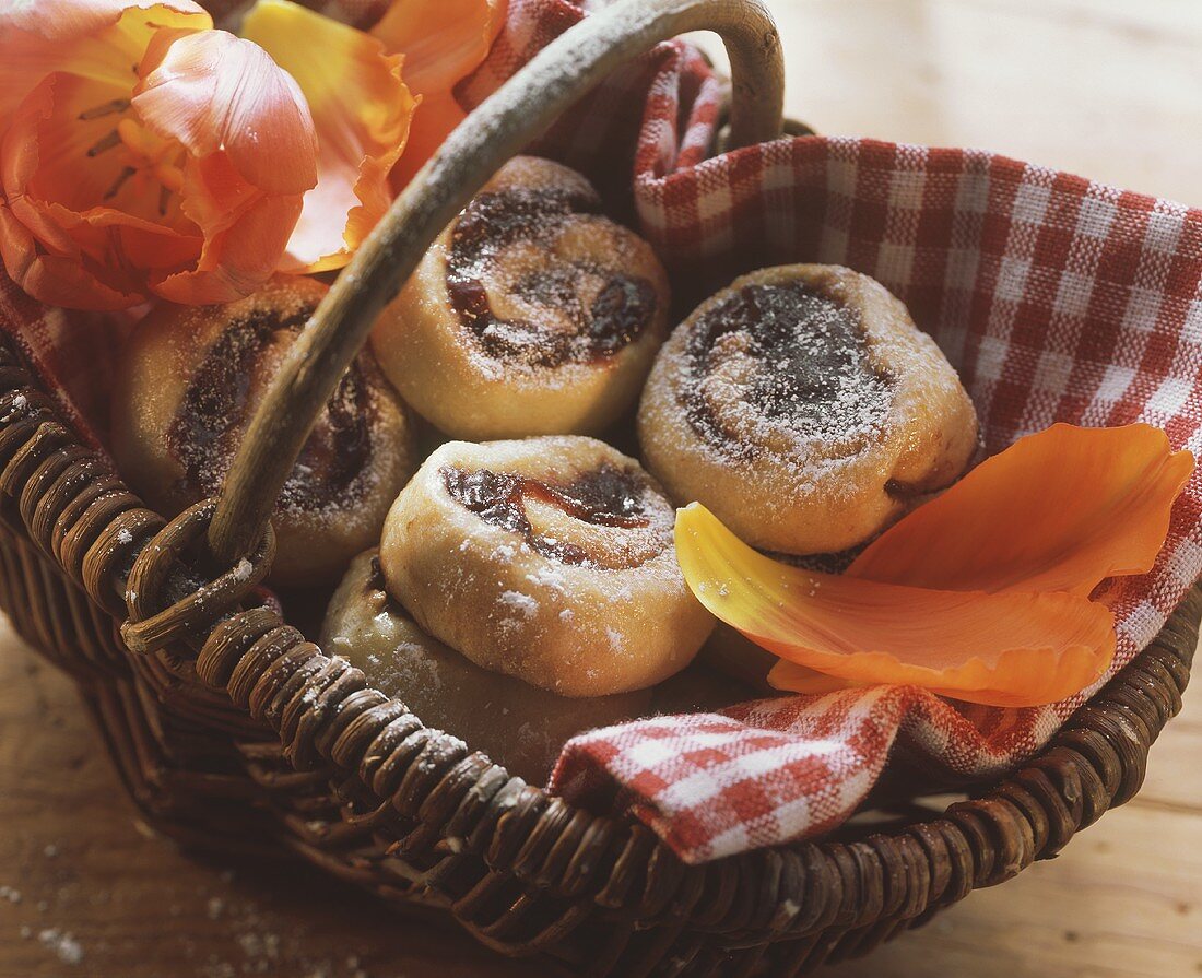 Hefeschnecken mit Pflaumenmus im Korb; Tulpen