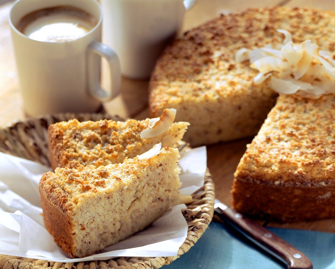 Coconut cake, pieces cut, and coffee