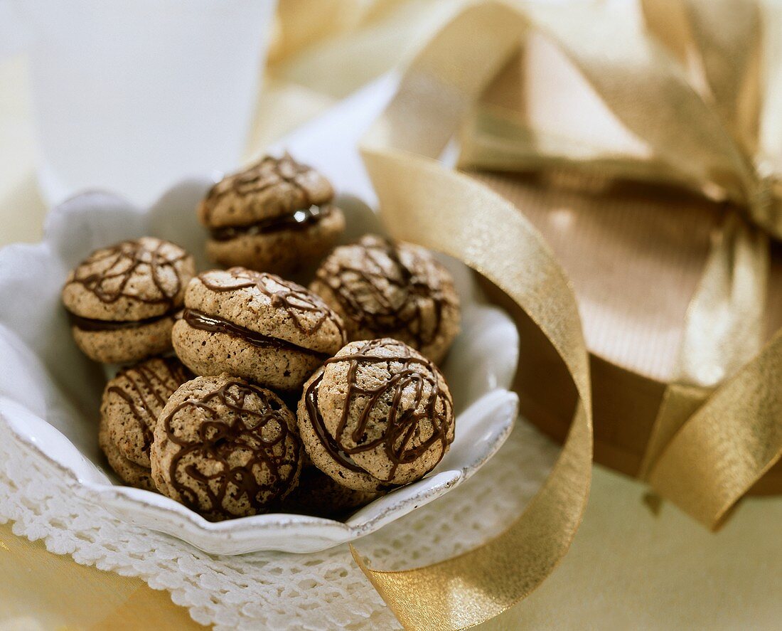 Mocha macaroons in a bowl; box with a gold bow