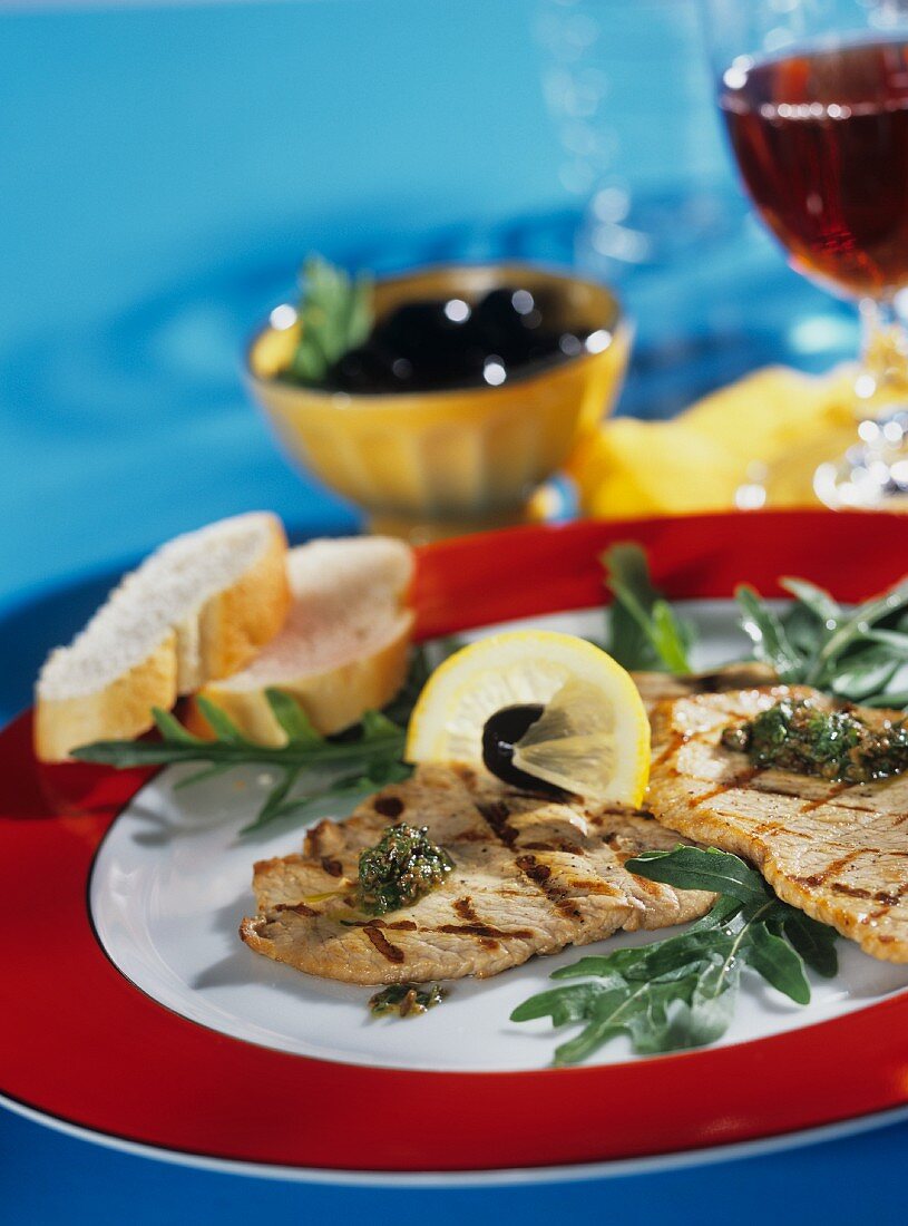 Zitronenschnitzel mit Oliven, Rucola und Weißbrot