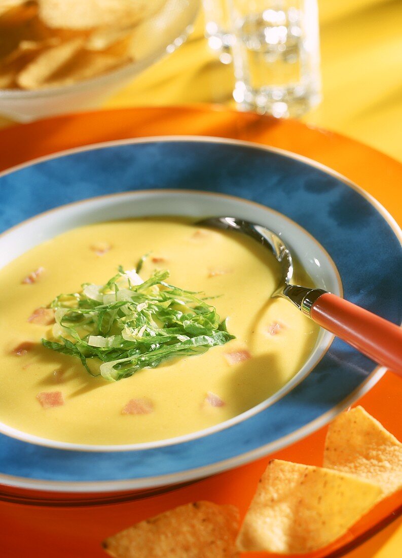 Maiscremesuppe mit Salatstreifen und Schinkenwürfeln