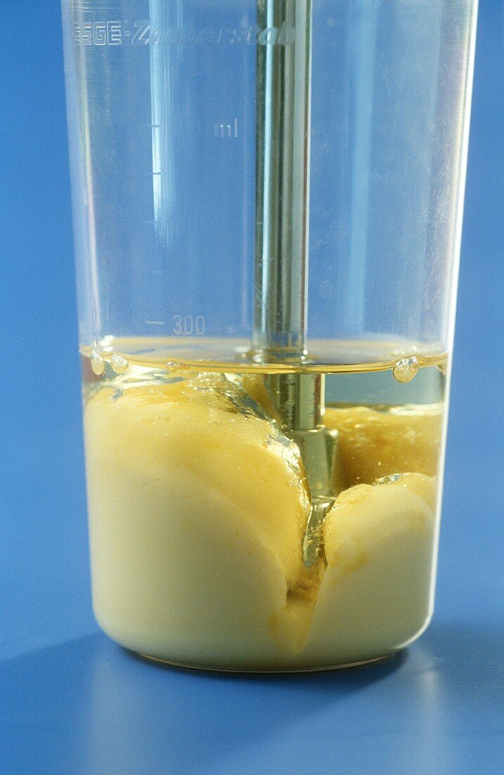 Stirring mayonnaise with mixer in measuring jug
