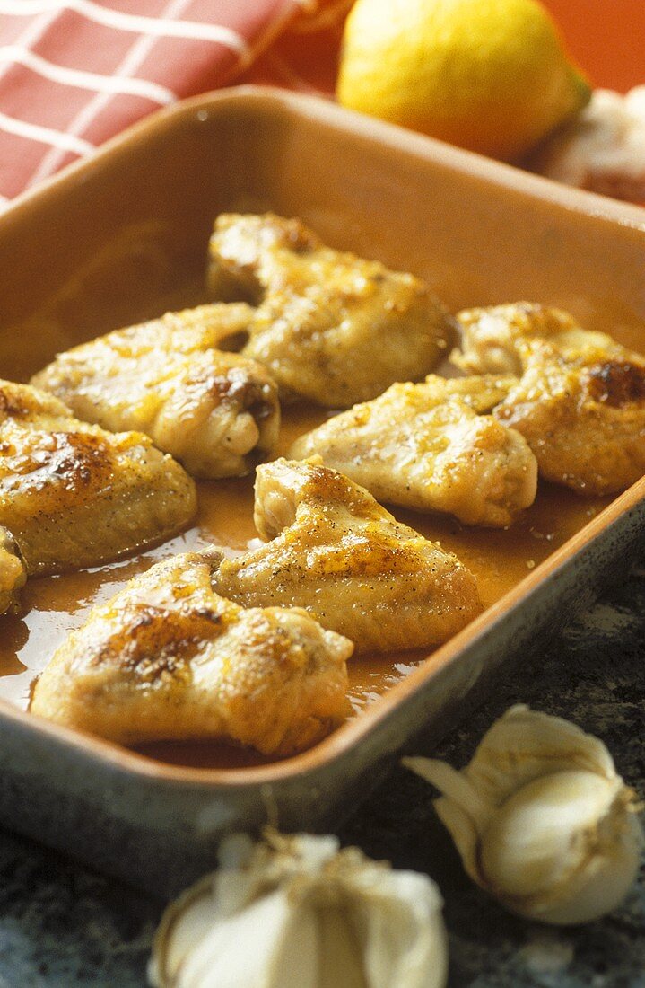 Chicken wings with honey and garlic in baking dish
