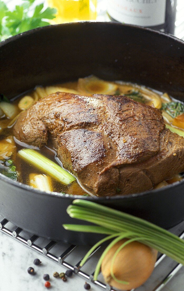 Roast venison with vegetables in stew pot