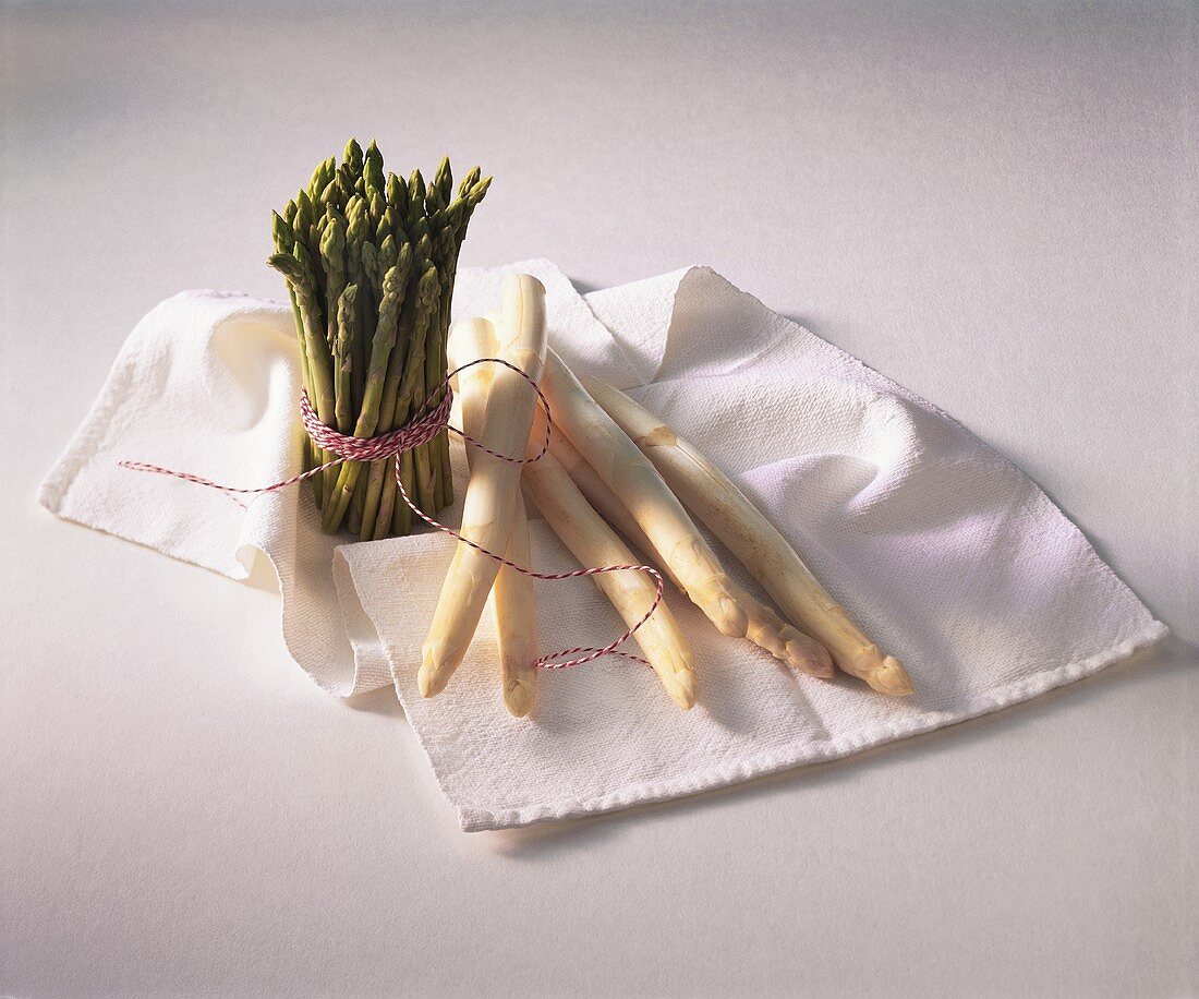 Bundle of green asparagus and white asparagus spears on cloth