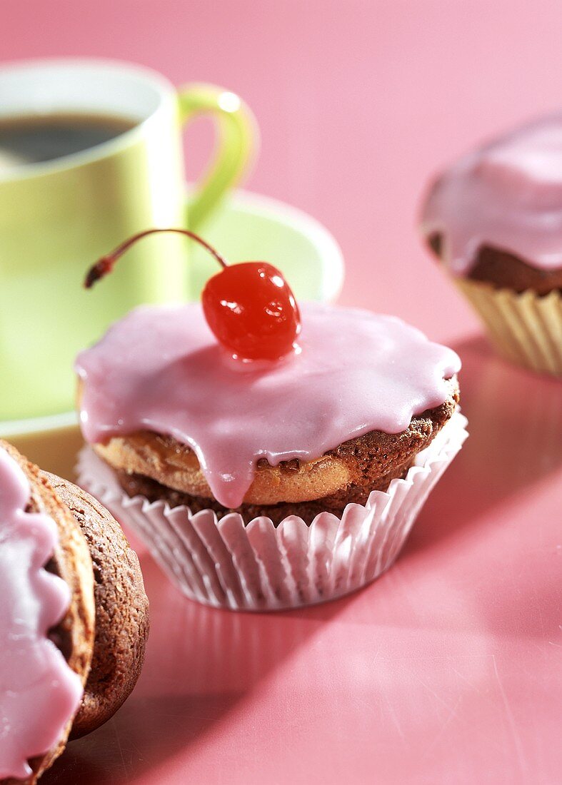 Cappuccino & cherry muffins with pink icing & cocktail cherry