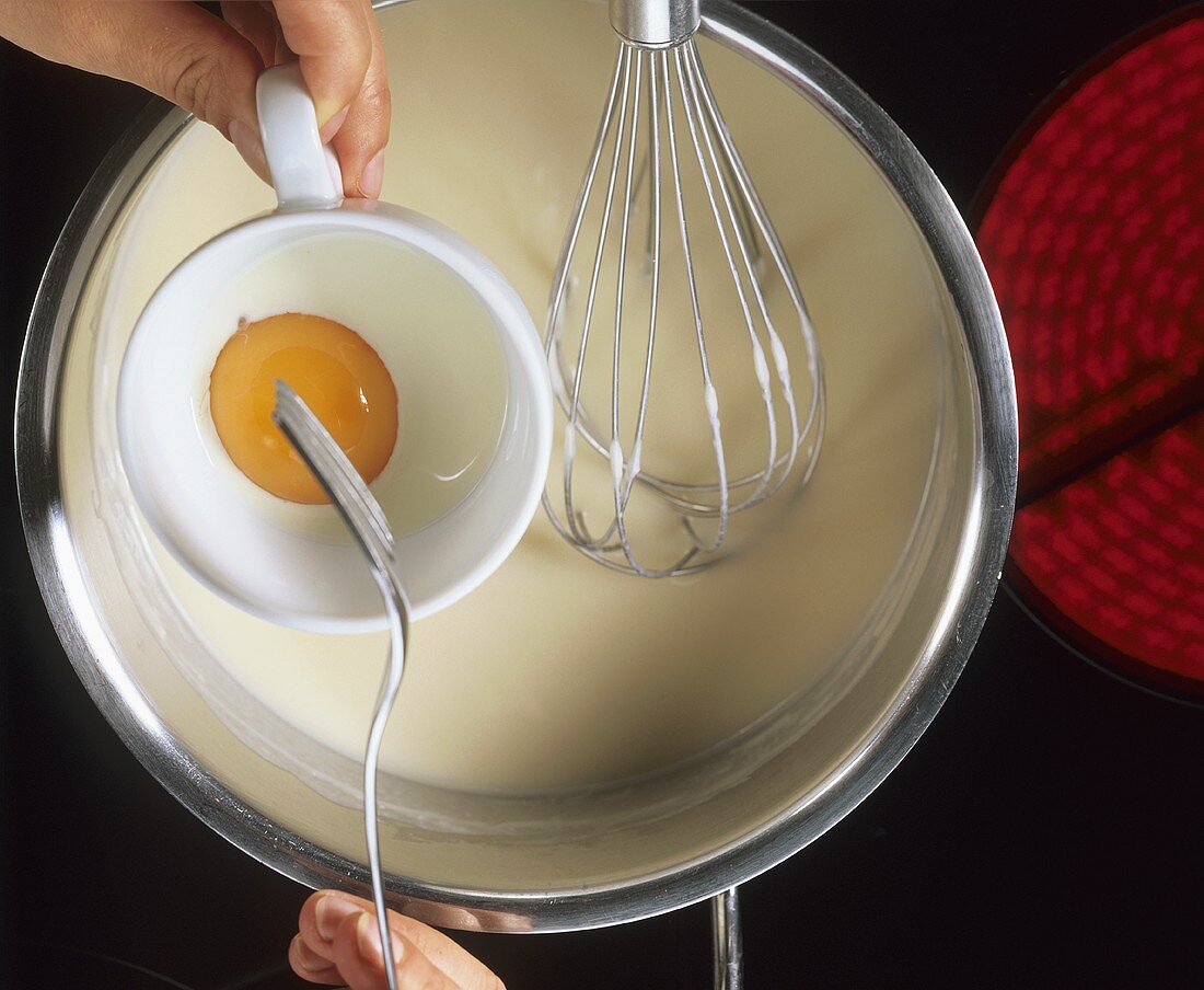 Making white sauce: add egg yolks with cream