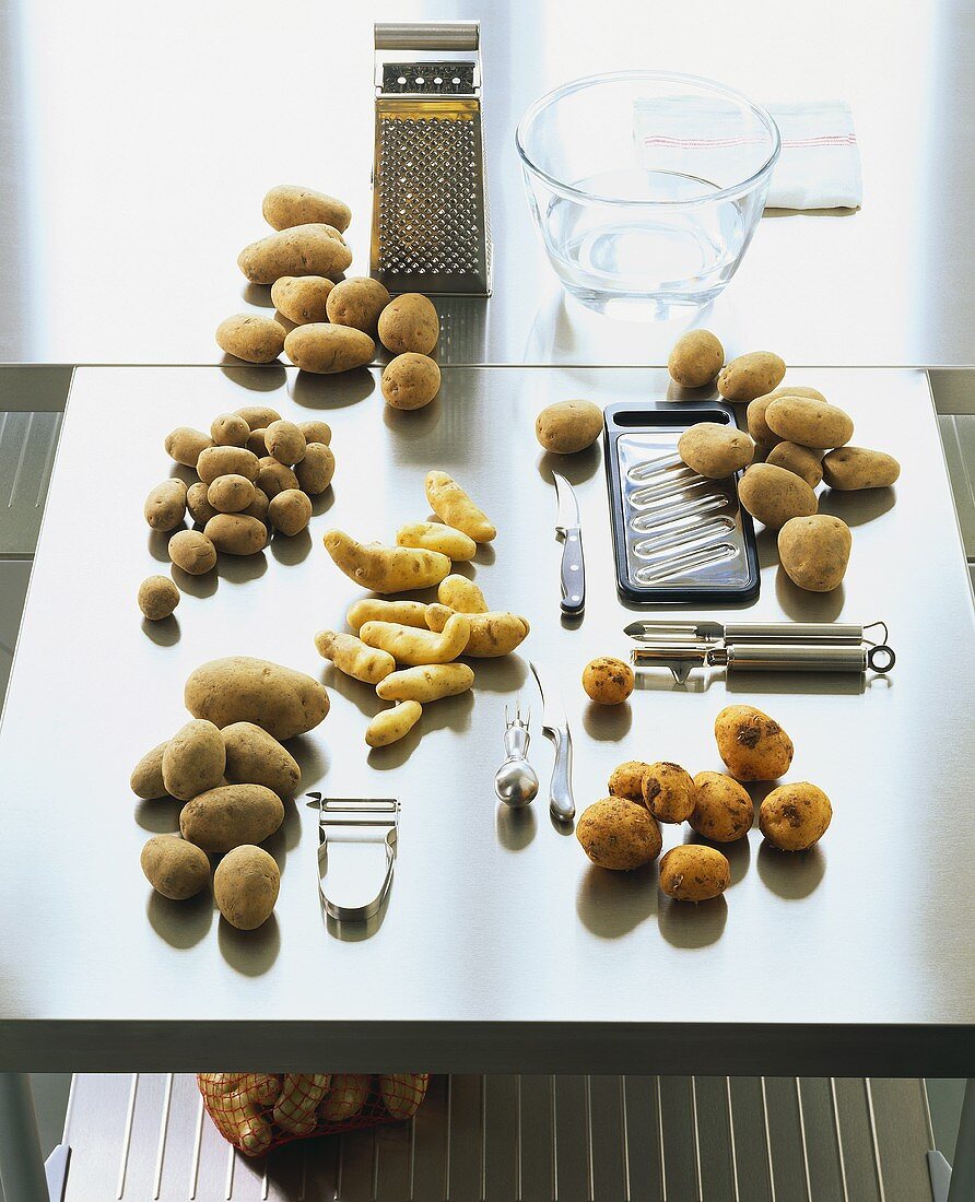 Verschiedene Kartoffelsorten und Küchenwerkzeug