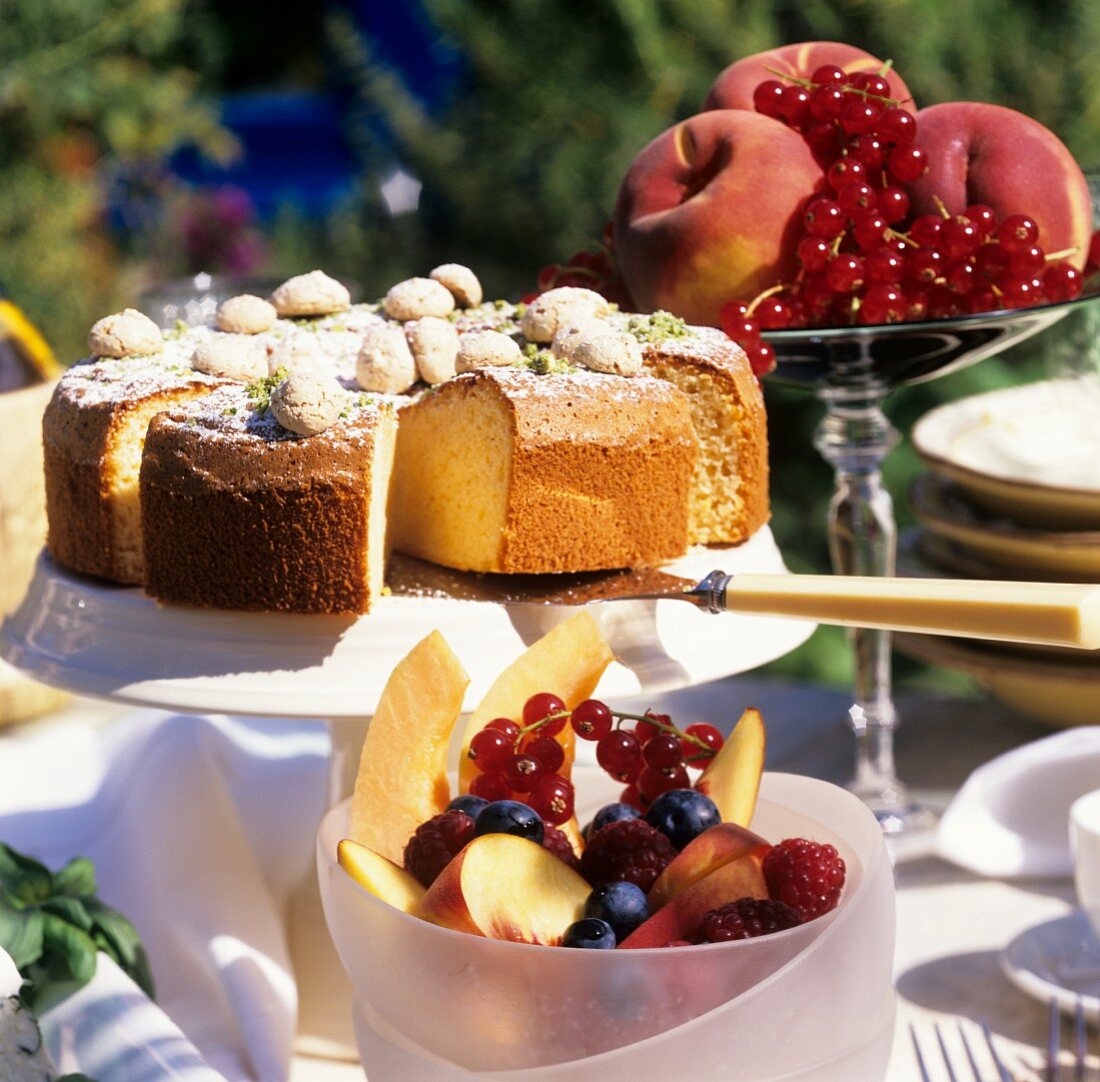 Almond cake and fresh fruit on table in open air