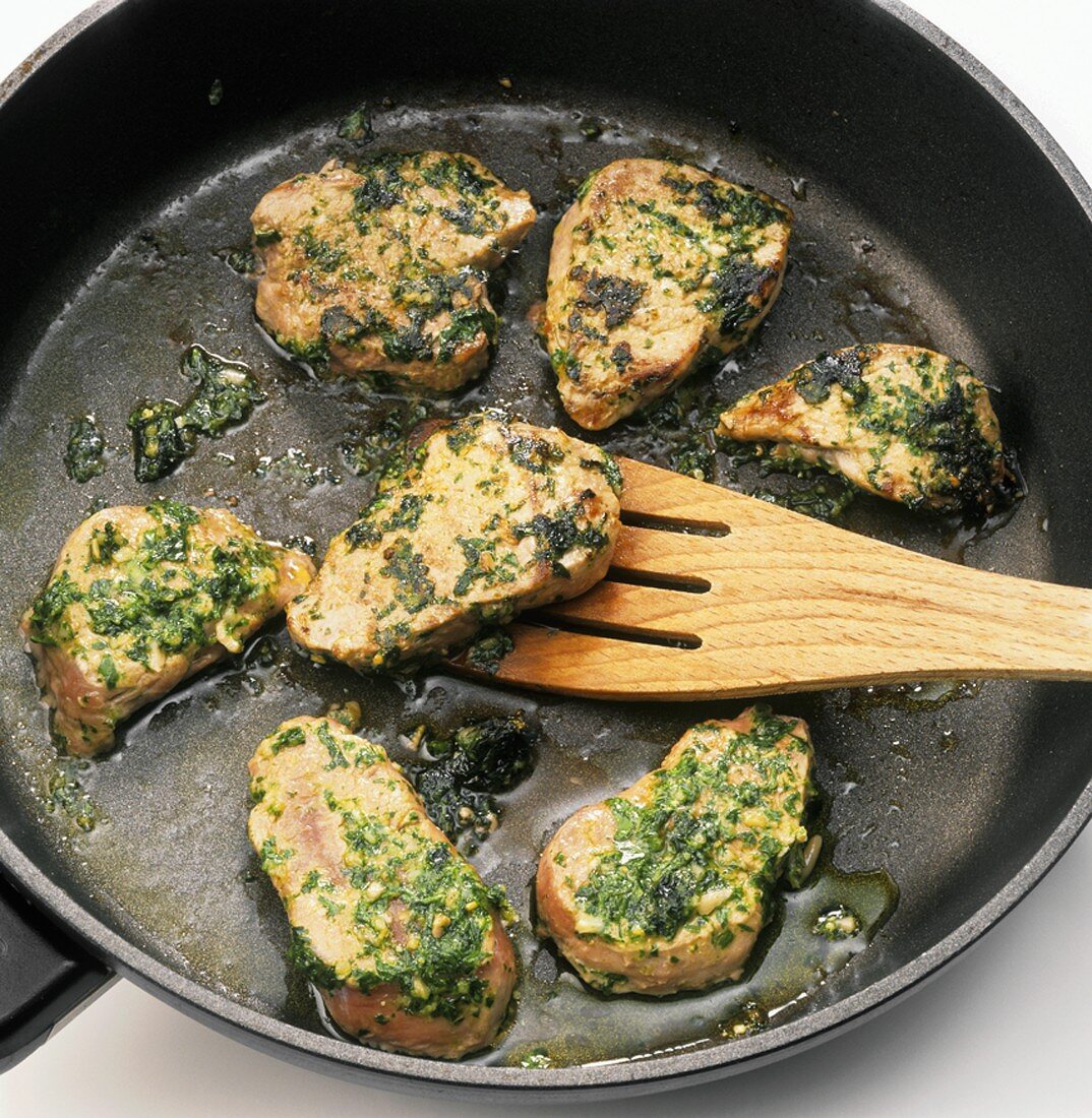 Sautéing pork fillet with pesto in frying pan