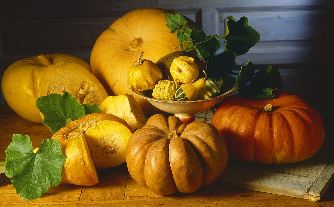 Various pumpkins and squashes on wooden platter