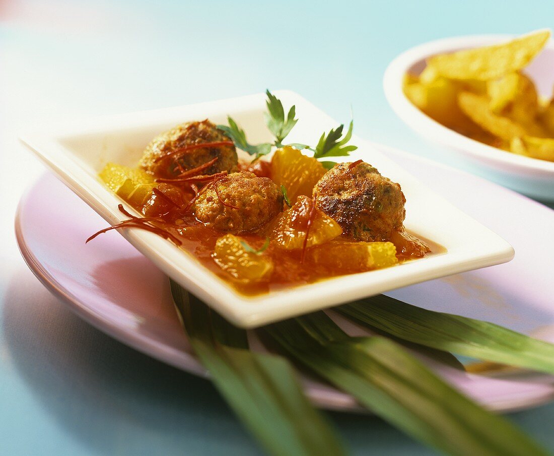 Meatballs in tomato and orange ragout with strips of chili