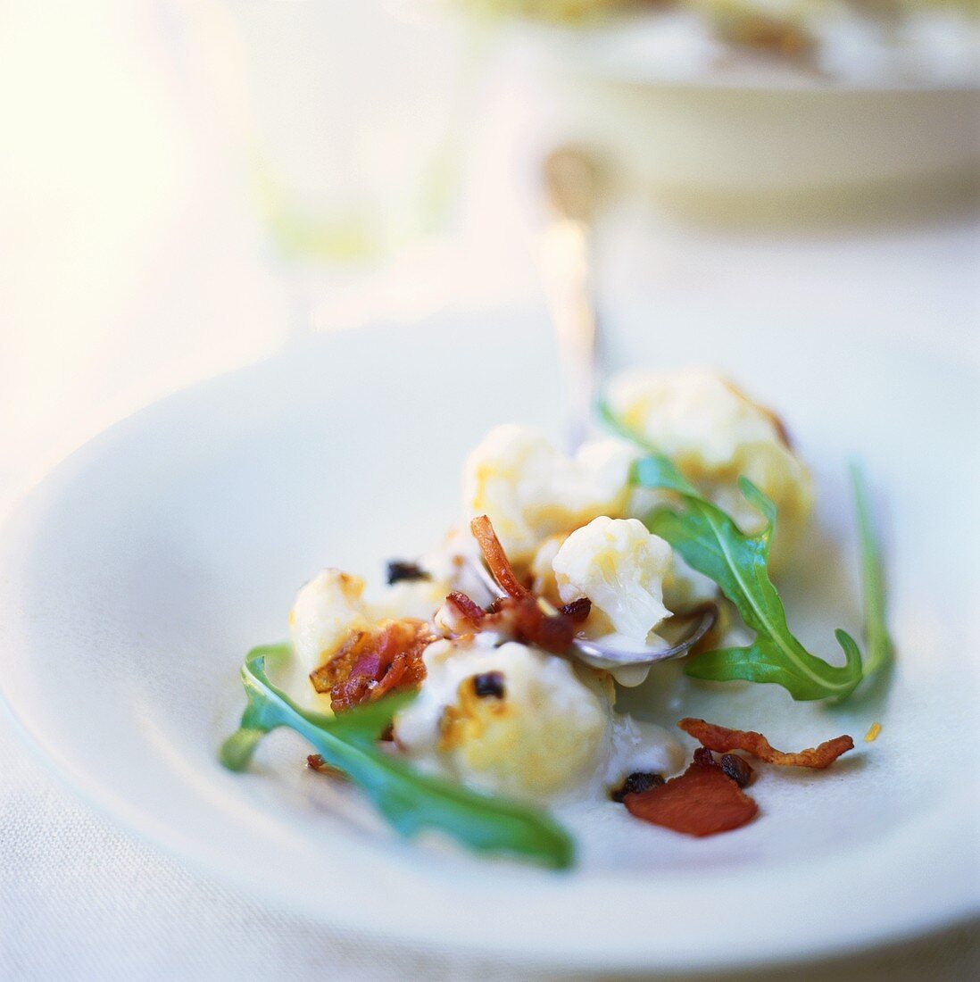 Blumenkohl in Sahnesauce mit gebratenem Speck und Rucola