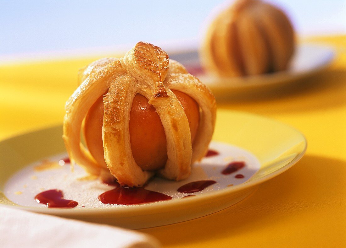 Stuffed apples in puff pastry with cherry sauce