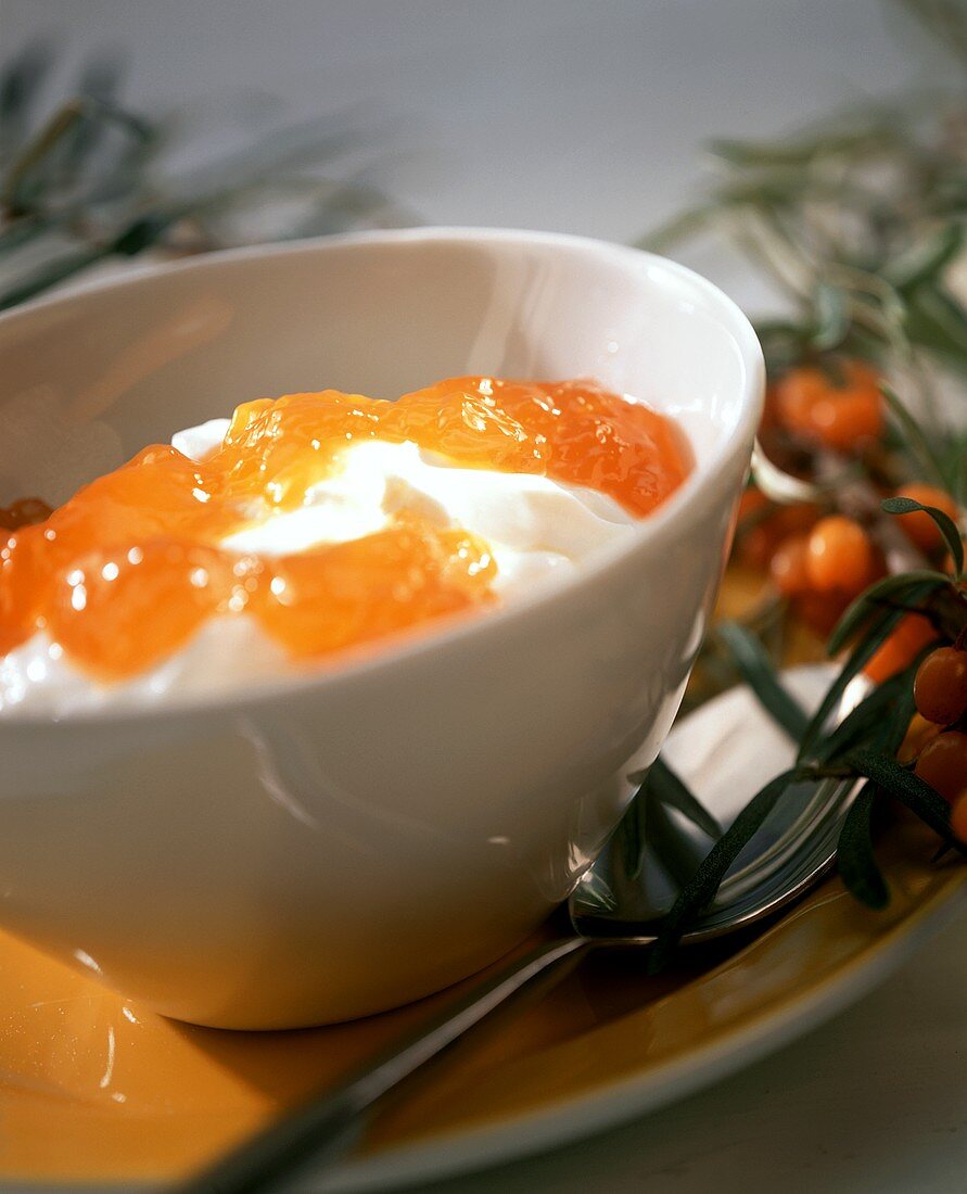 Quark mit Sanddornkonfitüre in weißem Schälchen