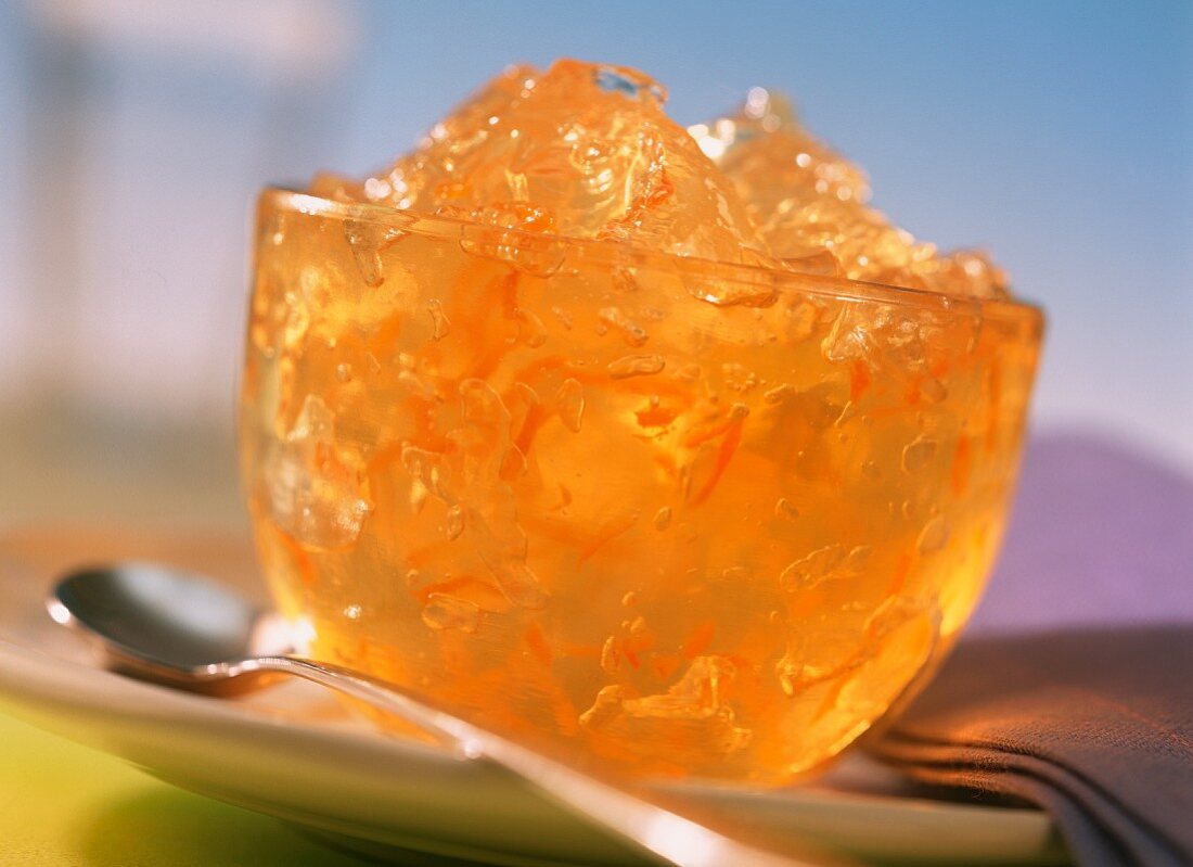 Orange jelly with strips of rind in glass bowl