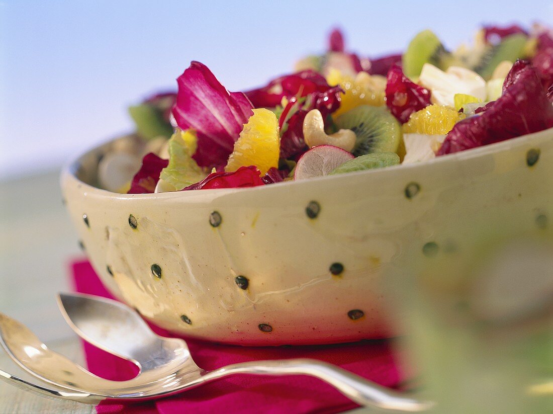 Mixed salad with kiwi fruits, oranges and walnut dressing
