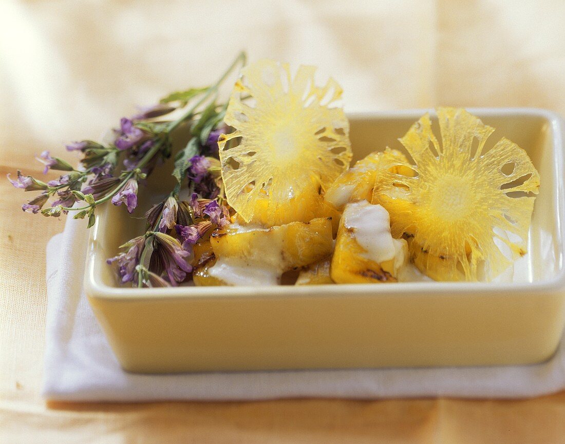 Steamed pineapple with coconut sauce and herb sprig