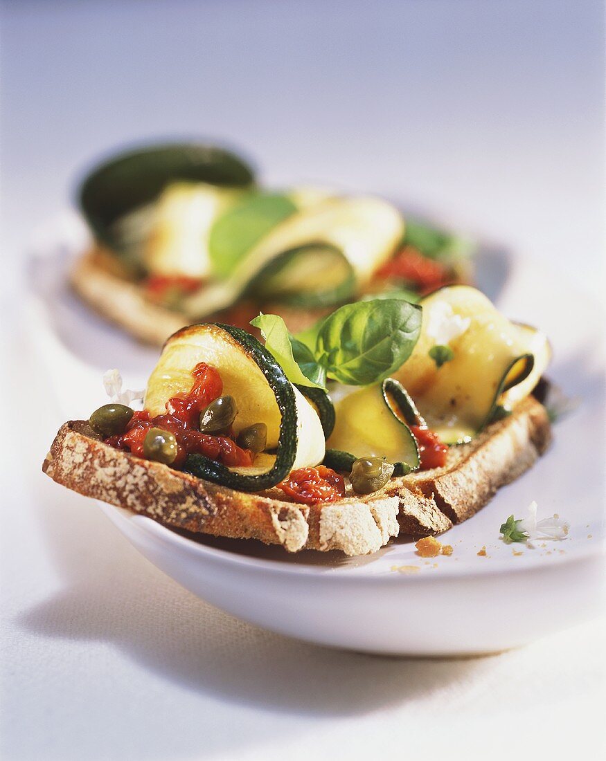 Belegtes Brot mit Zucchini, Kapern und frischem Basilikum