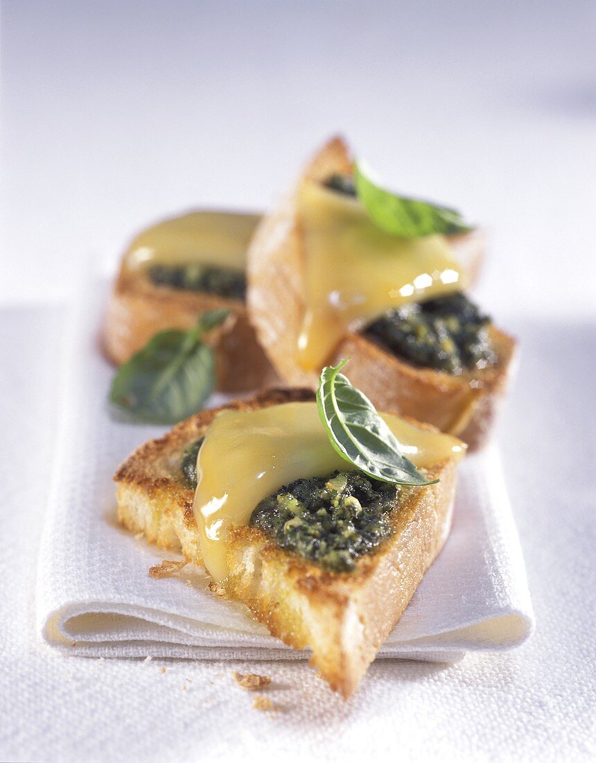 Pesto triangles with cheese and basil leaves
