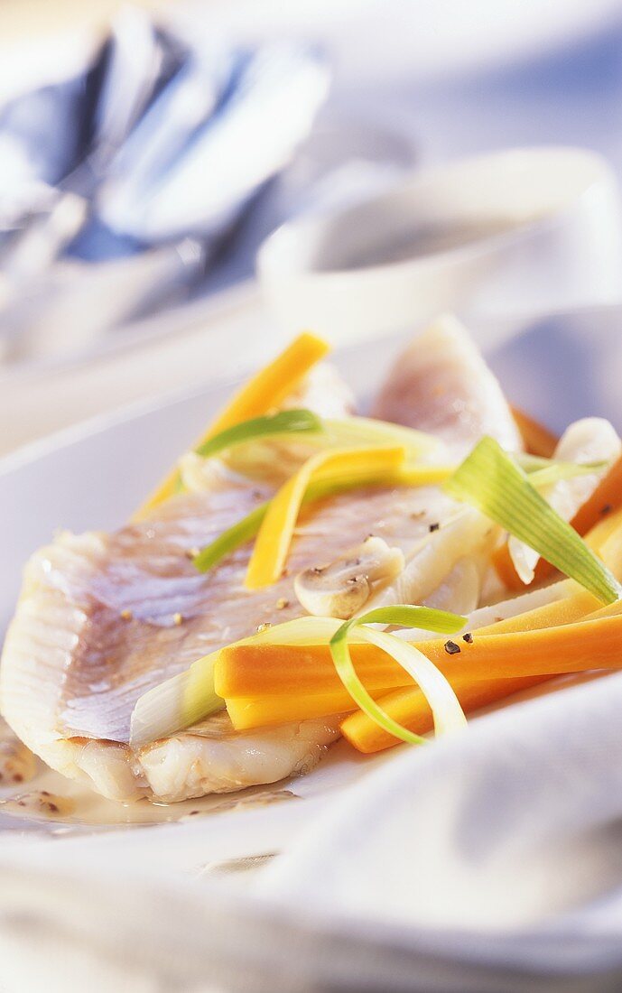 Cooked fish fillets with carrots and leeks