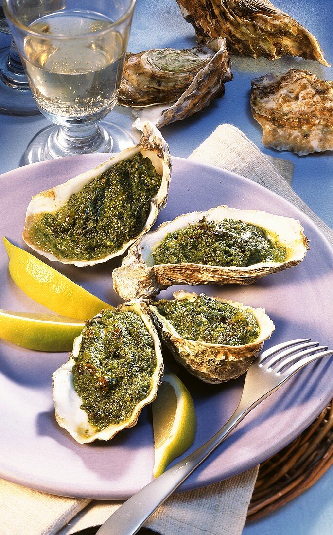 Baked oysters with lemon wedges; white wine