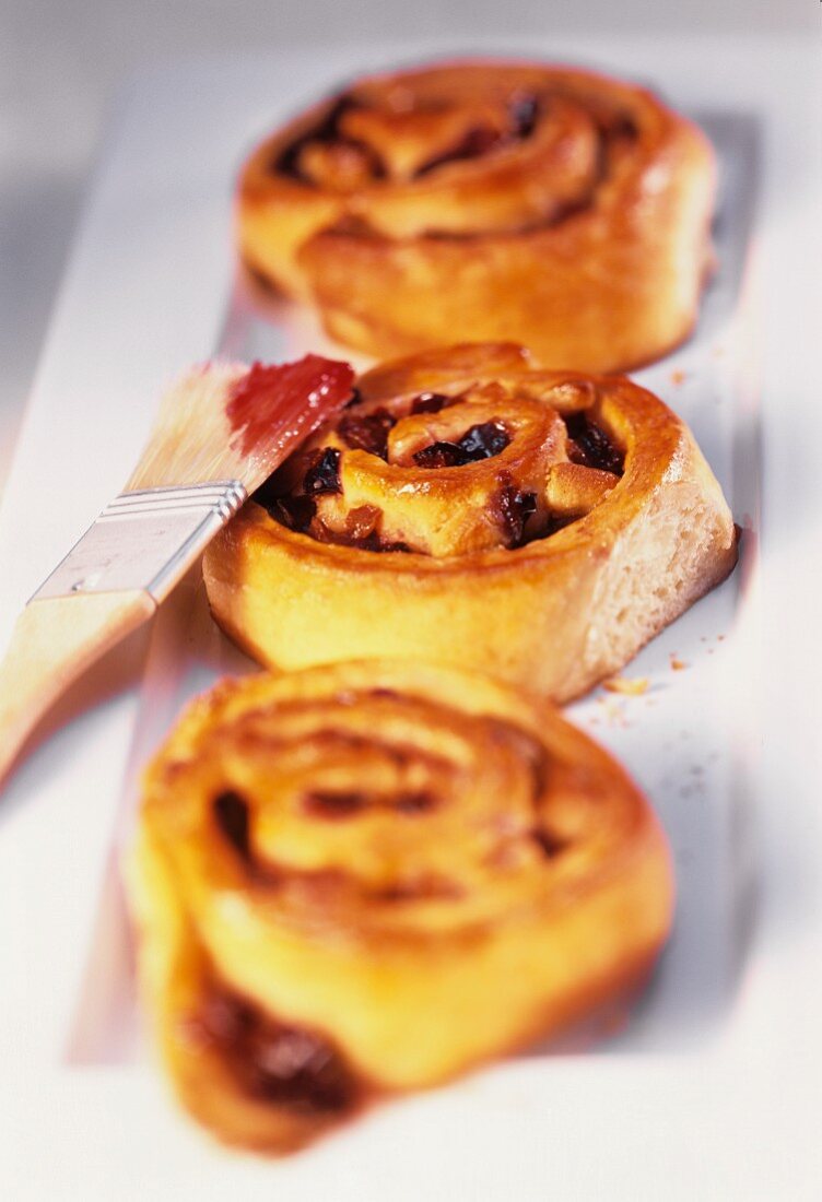 Snail rolls with plums; pastry brush